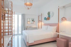 A modern bedroom with a bed, a wooden ladder, a bedside table, a mirror, and a wall with decorative plates. - Nama Boutique Hotel (Tinos)