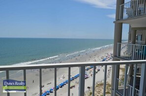 Blick auf den Strand vom Balkon aus, mit einem Schild für Dunes Realty.