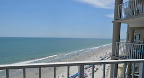 Blick auf den Strand vom Balkon aus, mit einem Schild für Dunes Realty.
