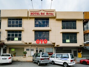 Un edificio con un cartel que dice "HOTEL Sri Sutra" y un logotipo destacado de "OYO".