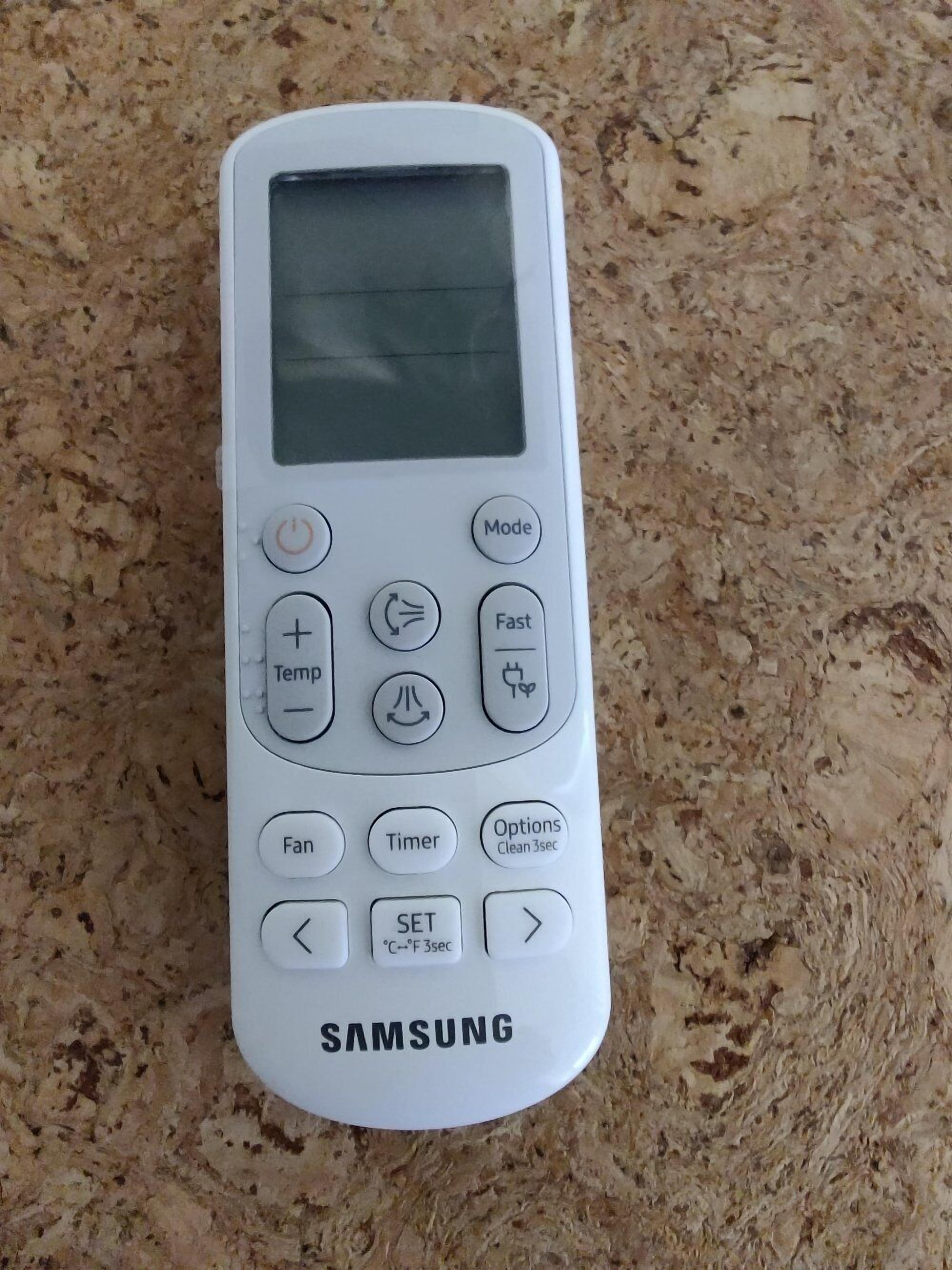 Ein weißes, tragbares Samsung-Gerät mit Bildschirm und verschiedenen Tasten, darunter Modus, Schnell, Ventilator, Timer und Optionen.