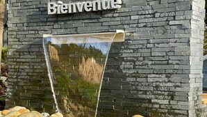 A stone wall with a 'Bienvenue' sign and a water feature. - Domaine les 2 Mondes (Aydat)