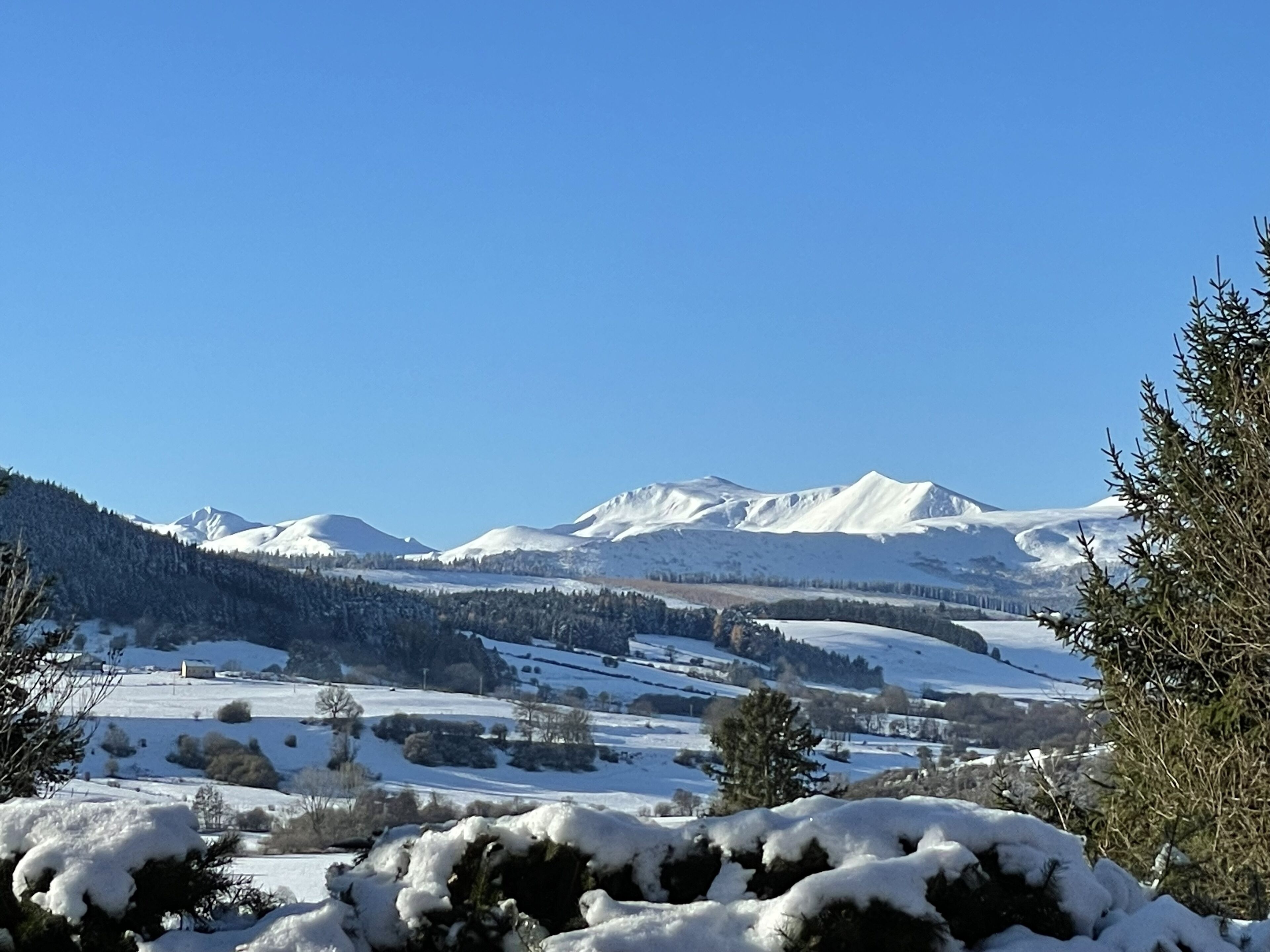 Un paysage de montagne enneigé sous un ciel dégagé.
