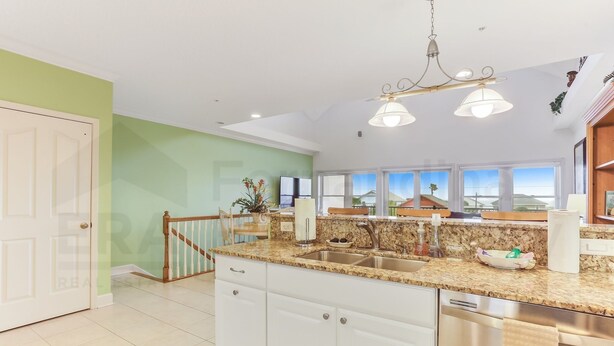 A spacious kitchen with a granite countertop, stainless steel appliances, and a large window offering a view of the countryside. - Dog Friendly Home with Ocean View from Balcony by RedAwning (Fernandina Beach)