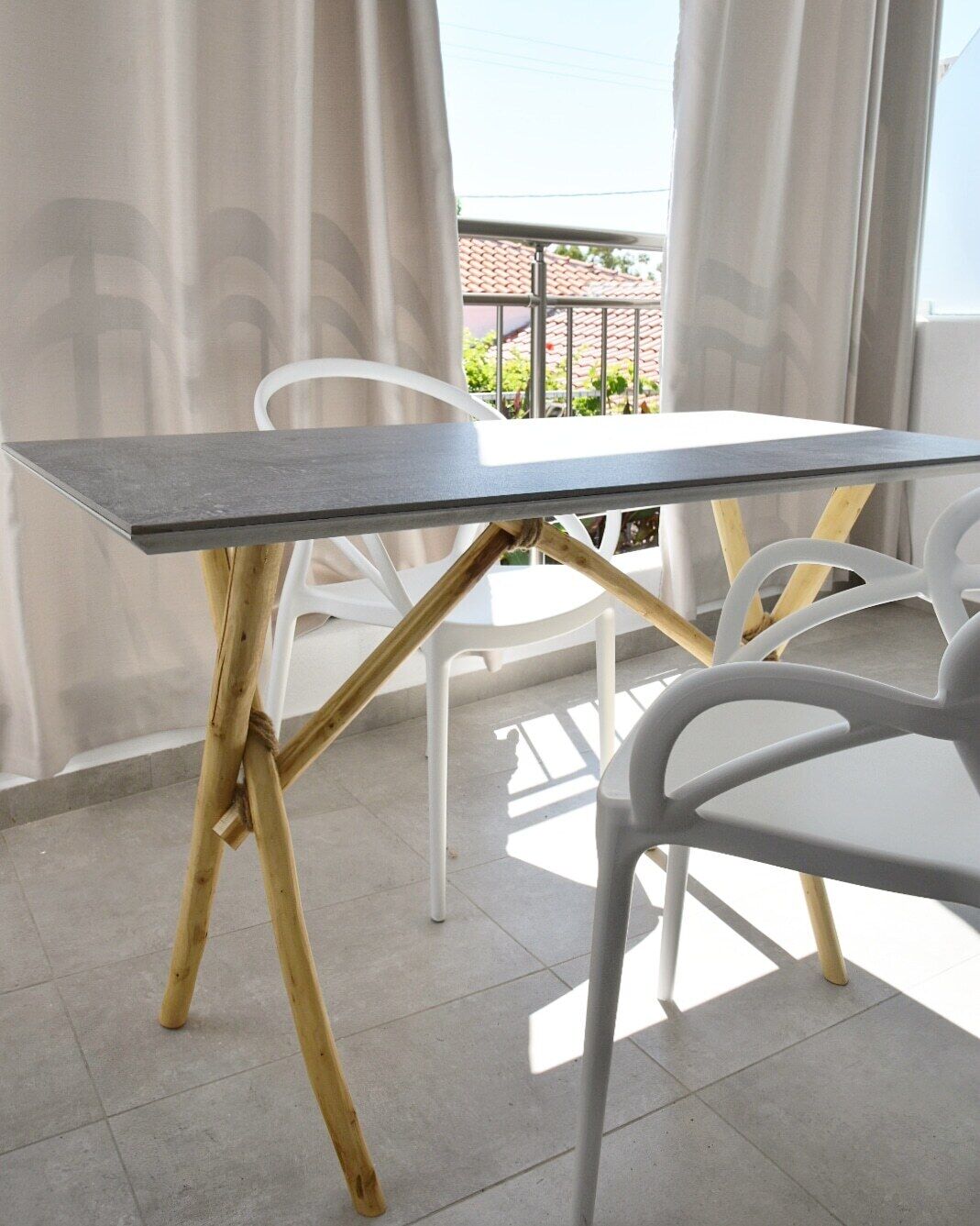 A balcony with a table and chairs, a view of the outside, and a railing.