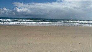 A beach with a clear sky and ocean waves.