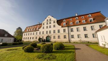 A large, historic building with a symmetrical facade, multiple windows, and a central entrance.