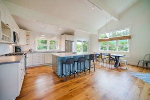 Enjoy cooking in this well-lit kitchen with a spacious island and bar stools.