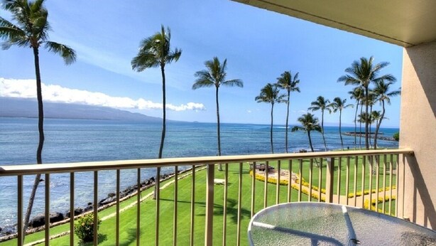 A balcony with a view of the ocean and palm trees. - Maalaea Kai 316 1 Bedroom Condo by RedAwning (Wailuku)