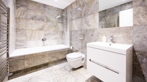 A modern bathroom with a bathtub, toilet, and vanity. - Up-market one Bedroom Apartment Just Minutes From the River Thames. Broughton rd (London)