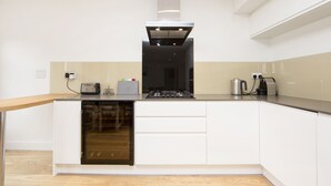 A modern kitchen with a built-in oven, a gas stove, and a stainless steel range hood. - Up-market one Bedroom Apartment Just Minutes From the River Thames. Broughton rd (London)