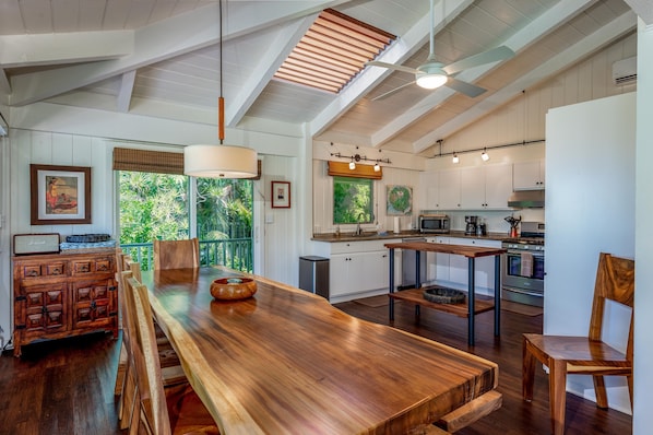 Enjoy meals at the dining table for four, surrounded by lush greenery views and modern kitchen amenities.
