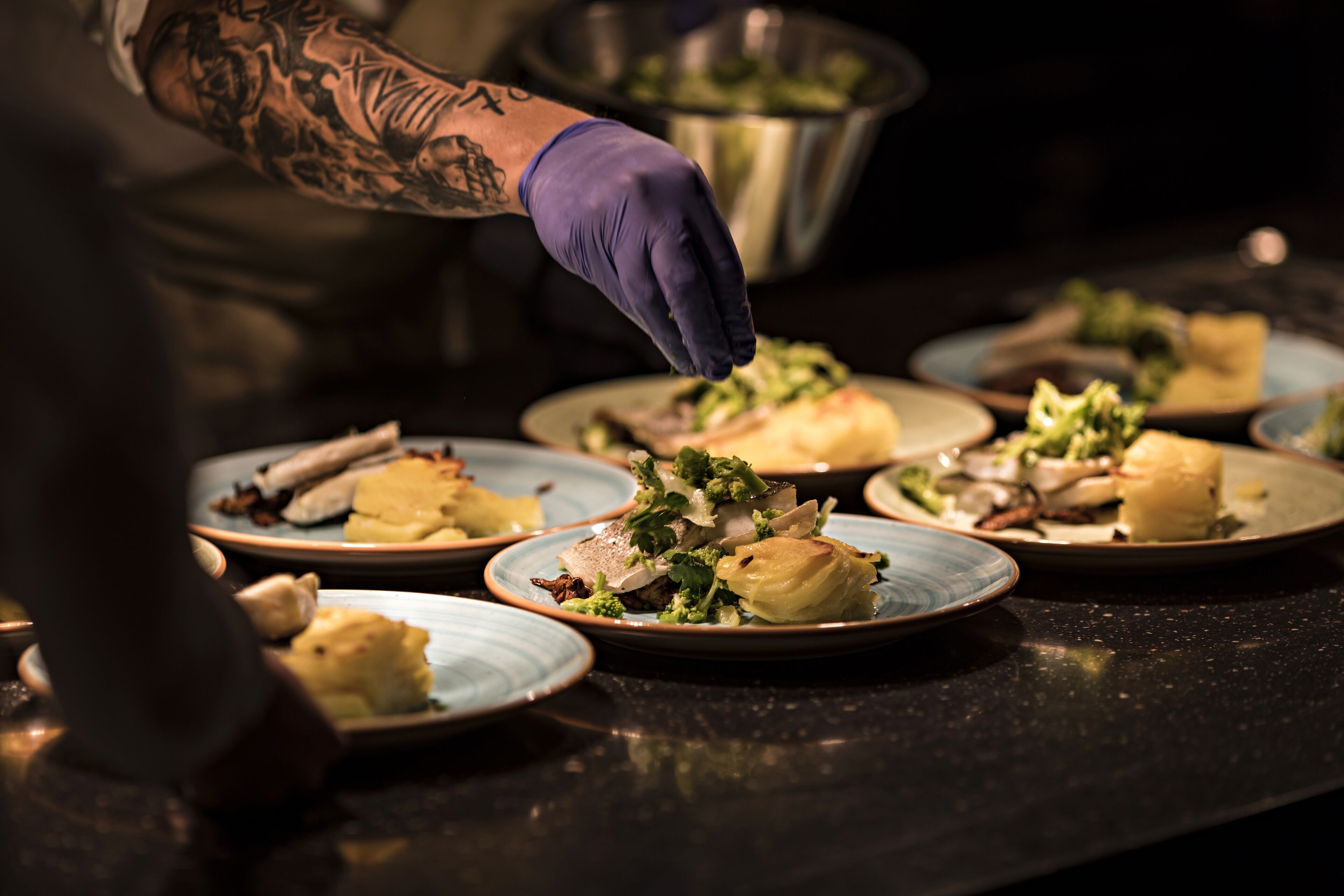 A chef preparing food on plates.