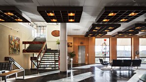 A spacious lobby with a staircase, a reception desk, and a seating area. - Rönneberga (Lidingo)