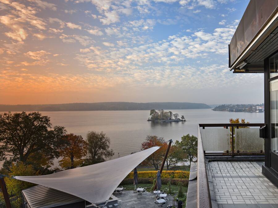A balcony with a view of a lake and distant island.