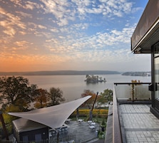 A balcony with a view of a lake and distant island.