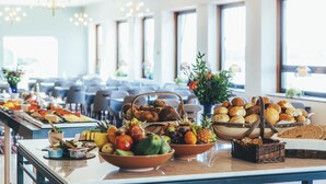 A buffet table with various food items and a seating area in the background. - Rönneberga (Lidingo)