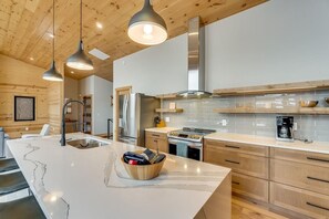 Enjoy cooking in this well-equipped kitchen with a central island, oven, and stainless steel range hood.