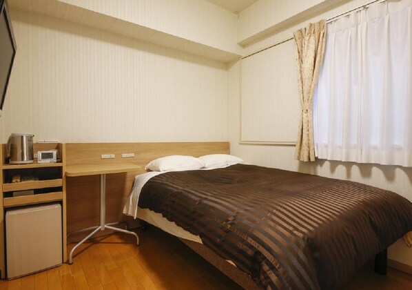 A compact hotel room with a single bed, a small desk with a kettle and a digital clock, and a compact refrigerator. - Wide bed single bed width 140cm WiFi correspond / Osaka Ōsaka (Osaka)