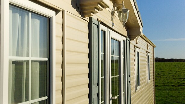 A beige house with large windows and a small porch area. - A comfortable Cornish countryside retreat in Coosewartha (Truro)