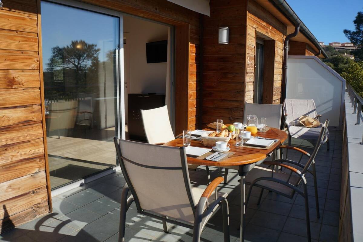 Een houten gevel met een schuifdeur naar een terras.