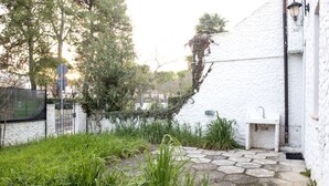 A white building with a stone pathway, a sink, and greenery. - M107 - Marcelli, three-room apartment with garden 200m from the sea (Marcelli)