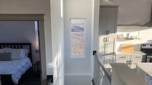 A modern interior with a staircase leading to a bedroom and a kitchen area. - 750 Square Feet, 1 Bedroom - Walk to Everything! Great for longer term stays. (Austin)