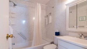 A bathroom with a glass-enclosed shower, a toilet, and a sink with a mirror above it. - Clairfont, Jobson's Cove / Warwick Long Bay/ Horseshoe Beach -  APARTMENT 1 (Warwick)