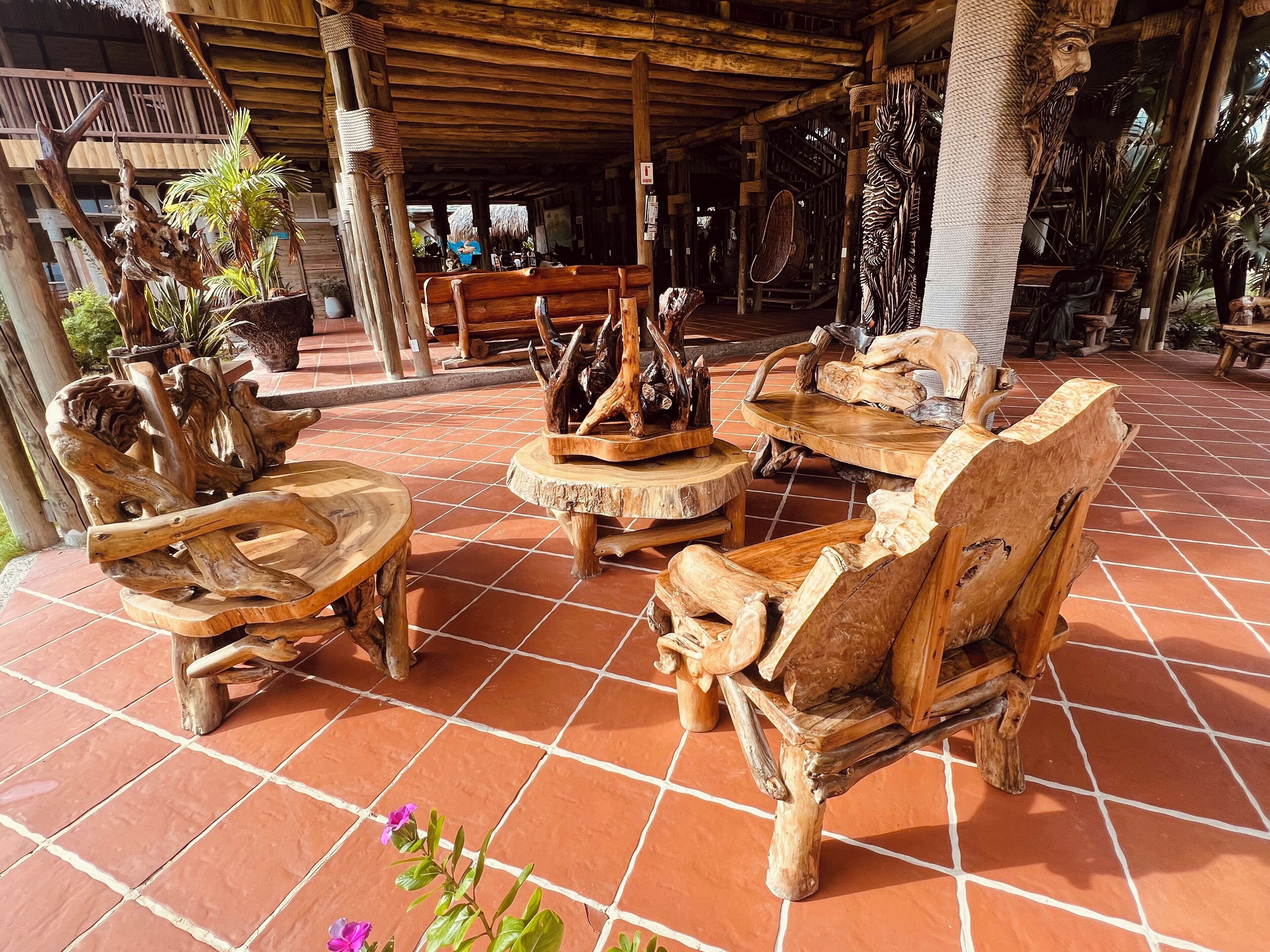 A wooden outdoor seating area with rustic furniture and a tiled floor.