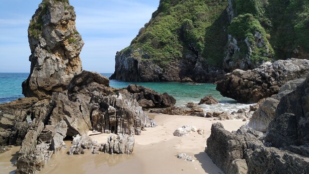 A rocky beach with clear turquoise water and a large rock formation. - MODERN APARTMENT IN PECHÓN (Pechón)