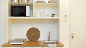A kitchen with a microwave, pots, a coffee maker, and a scale on the counter. - Brand New Guest room in the City Center★Free Wifi (Trieste)