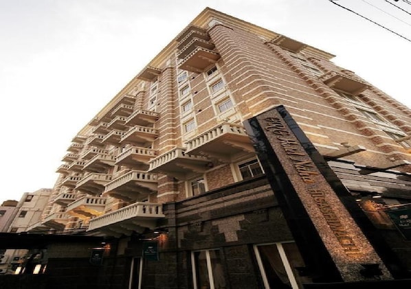 A tall, multi-story building with a distinctive architectural style, featuring balconies on each floor.