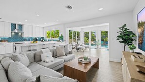 A modern living room with a large grey sectional sofa, a wooden coffee table, and a TV on a wooden stand.