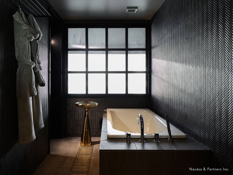 Ein modernes Badezimmer mit großem Fenster, einer Badewanne und einem Handtuchhalter.