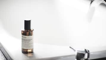 A bottle of Aesop aromatique room spray on a bathroom sink.