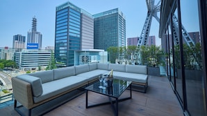 A modern outdoor seating area with a glass table, a sofa, and a champagne bottle. - The Tower Hotel Nagoya (Nagoya)