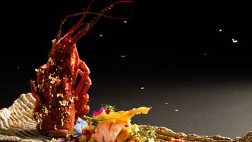 A lobster dish with a rustic presentation on a woven mat.