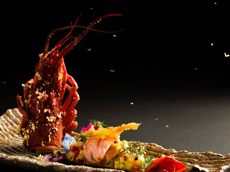 A lobster dish with a rustic presentation on a woven mat.