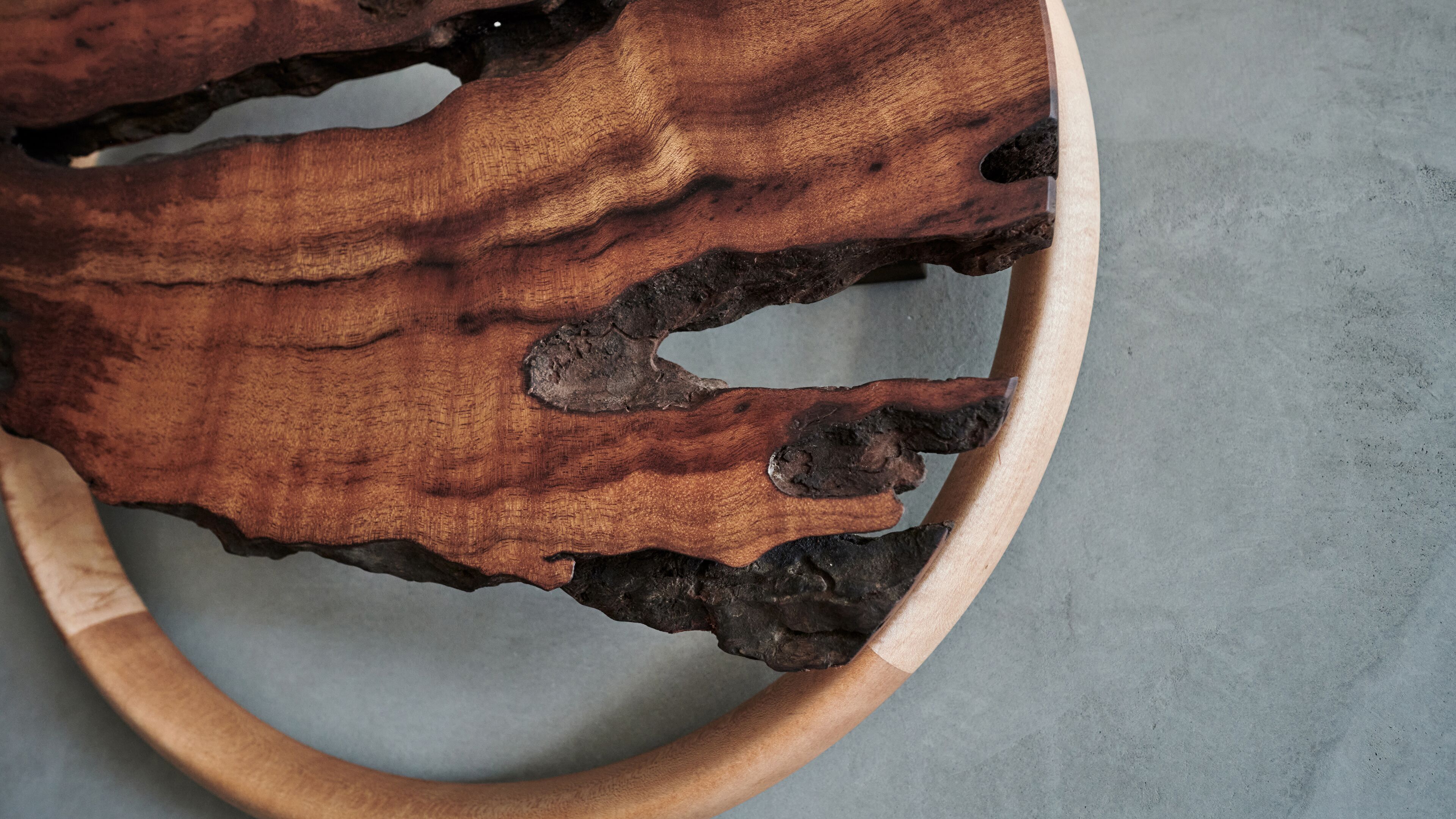 A wooden bowl with a rough texture and a natural, irregular shape.