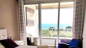 A bedroom with a large bed, a chair, and a view of the sea. - Fine apartment by the sea, beach, nice and quiet yet close to Center (Villajoyosa)