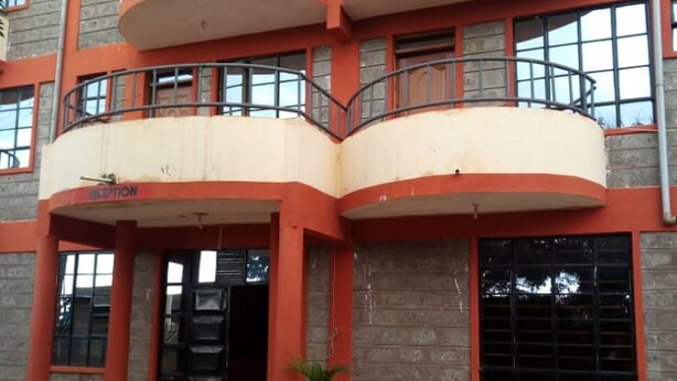 A multi-story building with a reception area, balconies, and potted plants. - Makindu Diamond Hotel (Makindu)