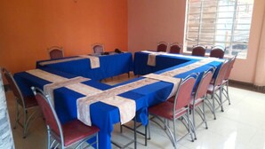 A conference room with tables covered in blue tablecloths and red chairs. - Makindu Diamond Hotel (Makindu)