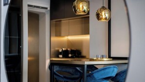 A modern kitchen with a central island, bar stools, and pendant lighting.