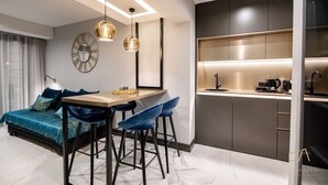A modern kitchen with a built-in island, bar stools, and a dining table.