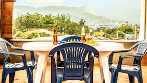 Un patio con una mesa y dos sillas, con vista a un paisaje montañoso.