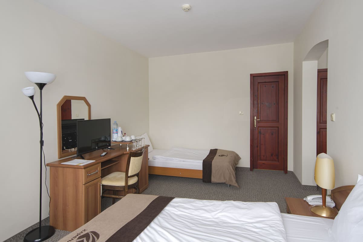 Een hotelkamer met een bed, bureau, stoel en bureaulamp.