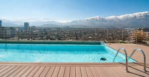 Ein Schwimmbad mit Blick auf schneebedeckte Berge im Hintergrund.
