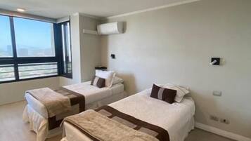 Two single beds with matching headboards and footboards, offering a city view.