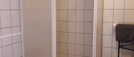 Un bagno con doccia, WC e porta asciugamani.