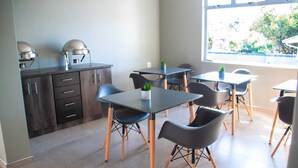 A modern kitchen with dark cabinets and a built-in espresso machine. - The Cato Suites Hotel (Durban)